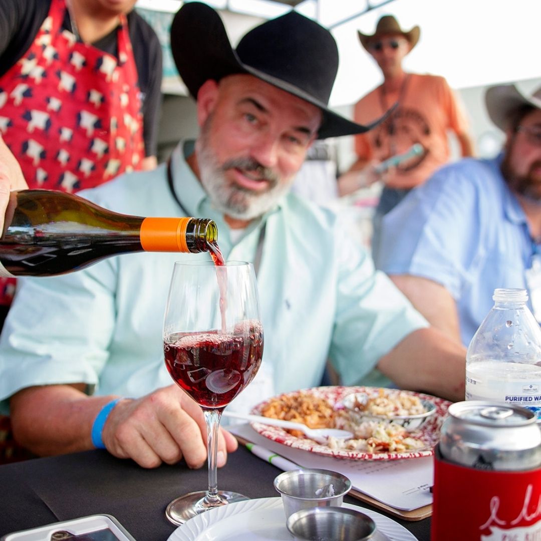 Mike Newton at Bacon Bash Texas is served a glass of Brennan Vineyards Wine.
