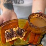 Winning 2025 Bacon Bash Texas dish: Spicy Maple Caramel Bacon Crack with Pederson’s Farms bacon next to warm spiked mulled apple cider.